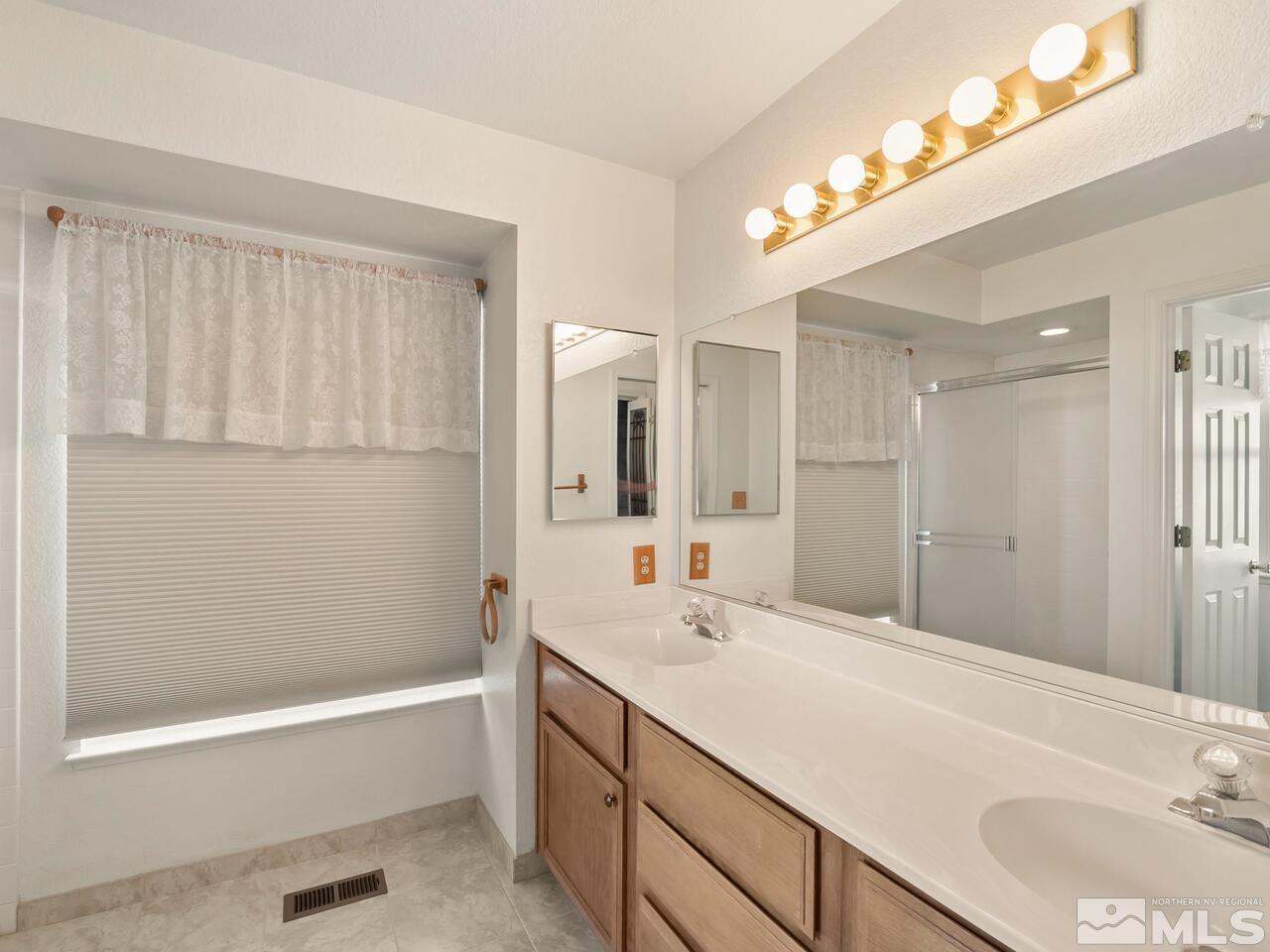 5670 West Rainbow Ridge Court Reno, NV 89523 - Photo 29 of 36 a bathroom with a tub a sink and a mirror