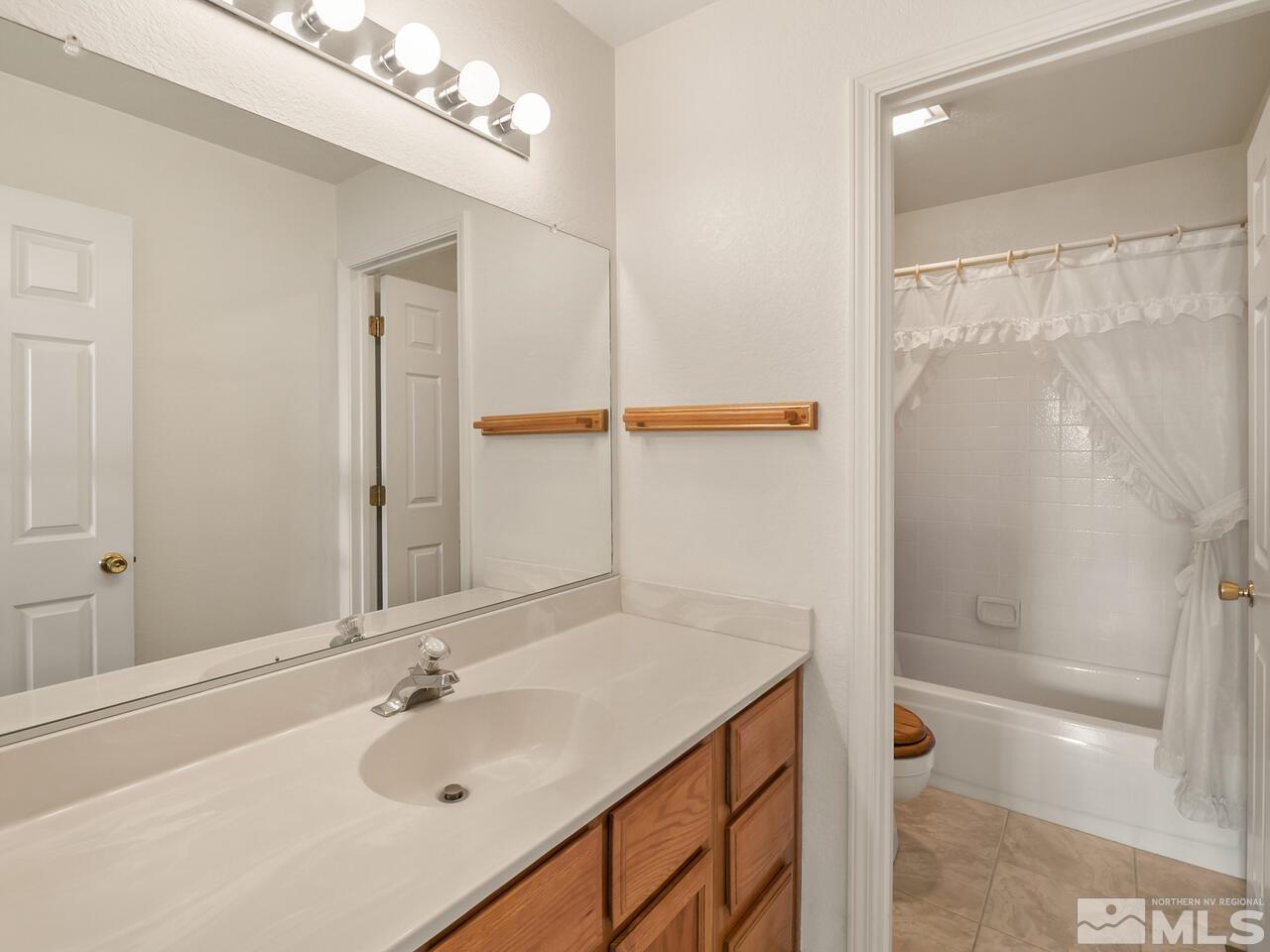 5670 West Rainbow Ridge Court Reno, NV 89523 - Photo 30 of 36 a bathroom with a sink and a mirror