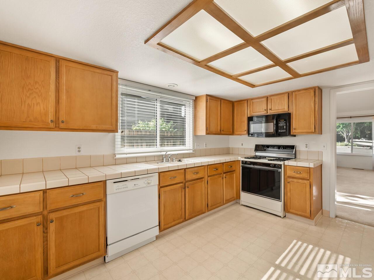 5670 West Rainbow Ridge Court Reno, NV 89523 - Photo 10 of 36 a kitchen with granite countertop appliances cabinets and a sink
