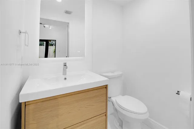 a bathroom with a sink a toilet and mirror