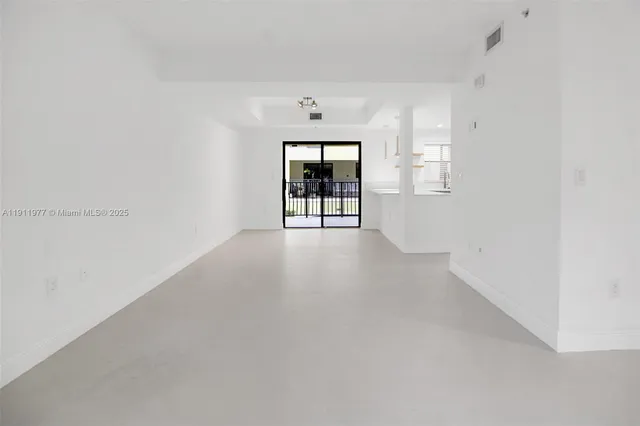 an empty room with windows and cabinet