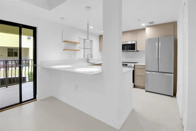 a view of kitchen with stainless steel appliances refrigerator oven and cabinets