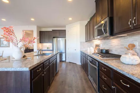 a kitchen with stainless steel appliances granite countertop a sink stove and refrigerator