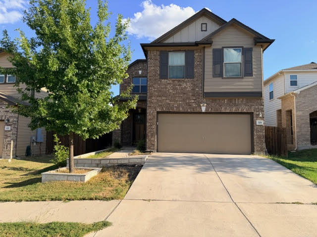a front view of a house with a yard and garage
