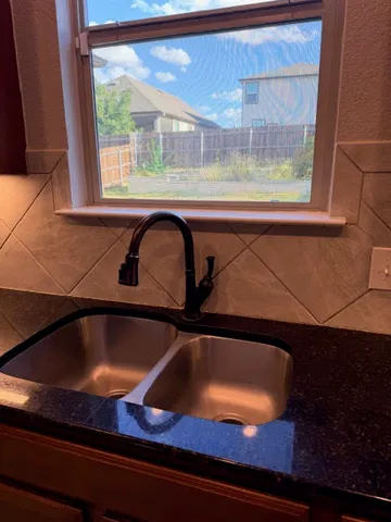 a kitchen with a sink a stove and cabinets