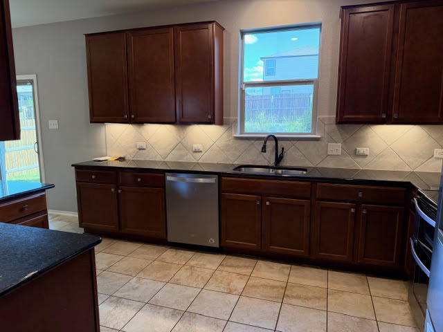 329 Los Cobos Lane Georgetown, TX 78626 - Photo 18 of 40 a kitchen with a sink a stove and cabinets