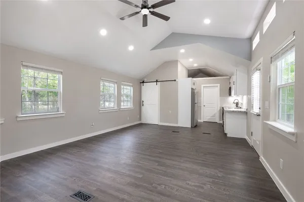 a view of an empty room with a window and wooden floor