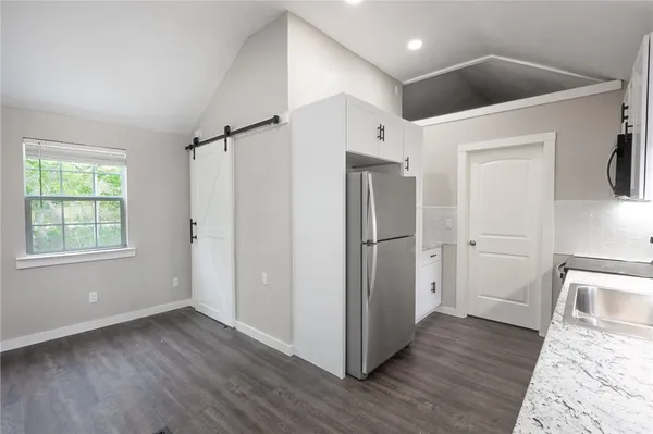 a view of a hallway with wooden floor and entryway
