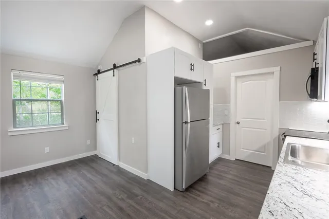 a view of a hallway with wooden floor and entryway