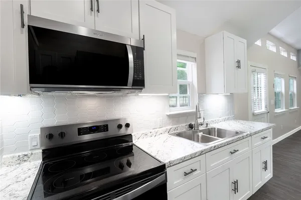 a kitchen with a sink stove and microwave