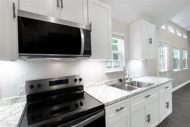 a kitchen with a sink stove and microwave