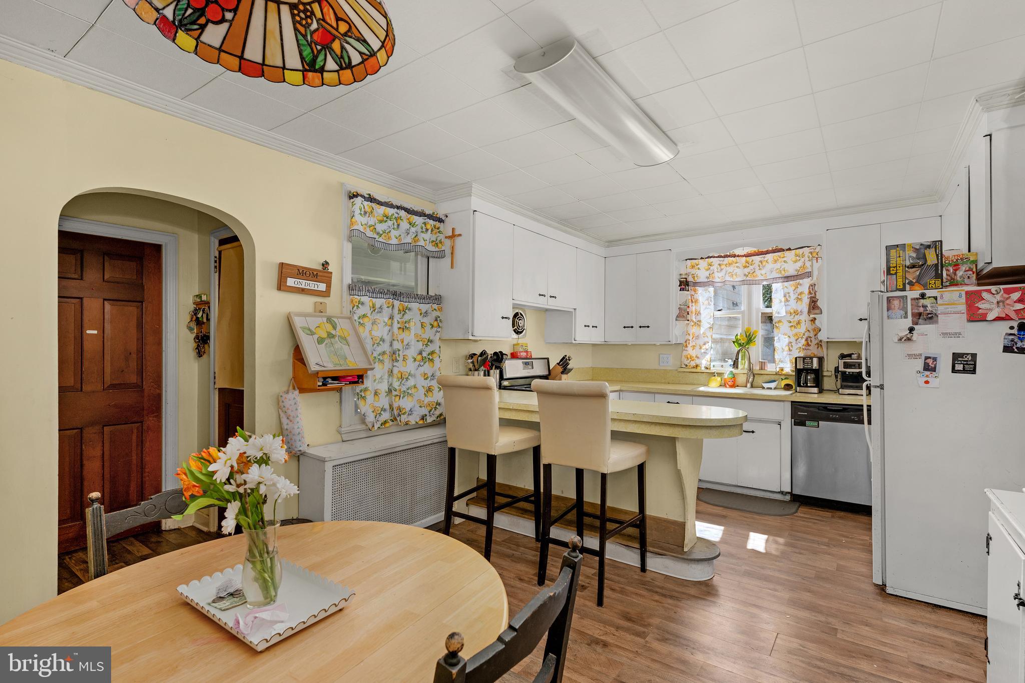 730 McAllister Street Hanover, PA 17331 - Photo 10 of 46 a kitchen with stainless steel appliances kitchen island granite countertop a table chairs in it and wooden floors
