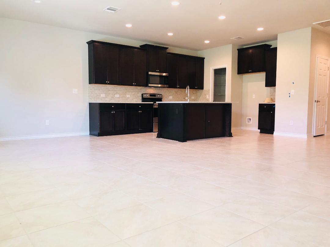 1308 Eagle Ridge Trail Leander, TX 78641 - Photo 16 of 16 Kitchen with dark cabinets, stainless steel microwave, electric stove, open floor plan, and recessed lighting