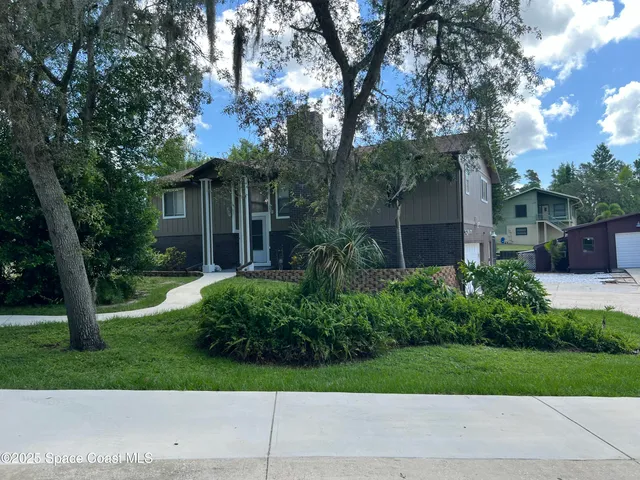 a view of a house with garden and trees