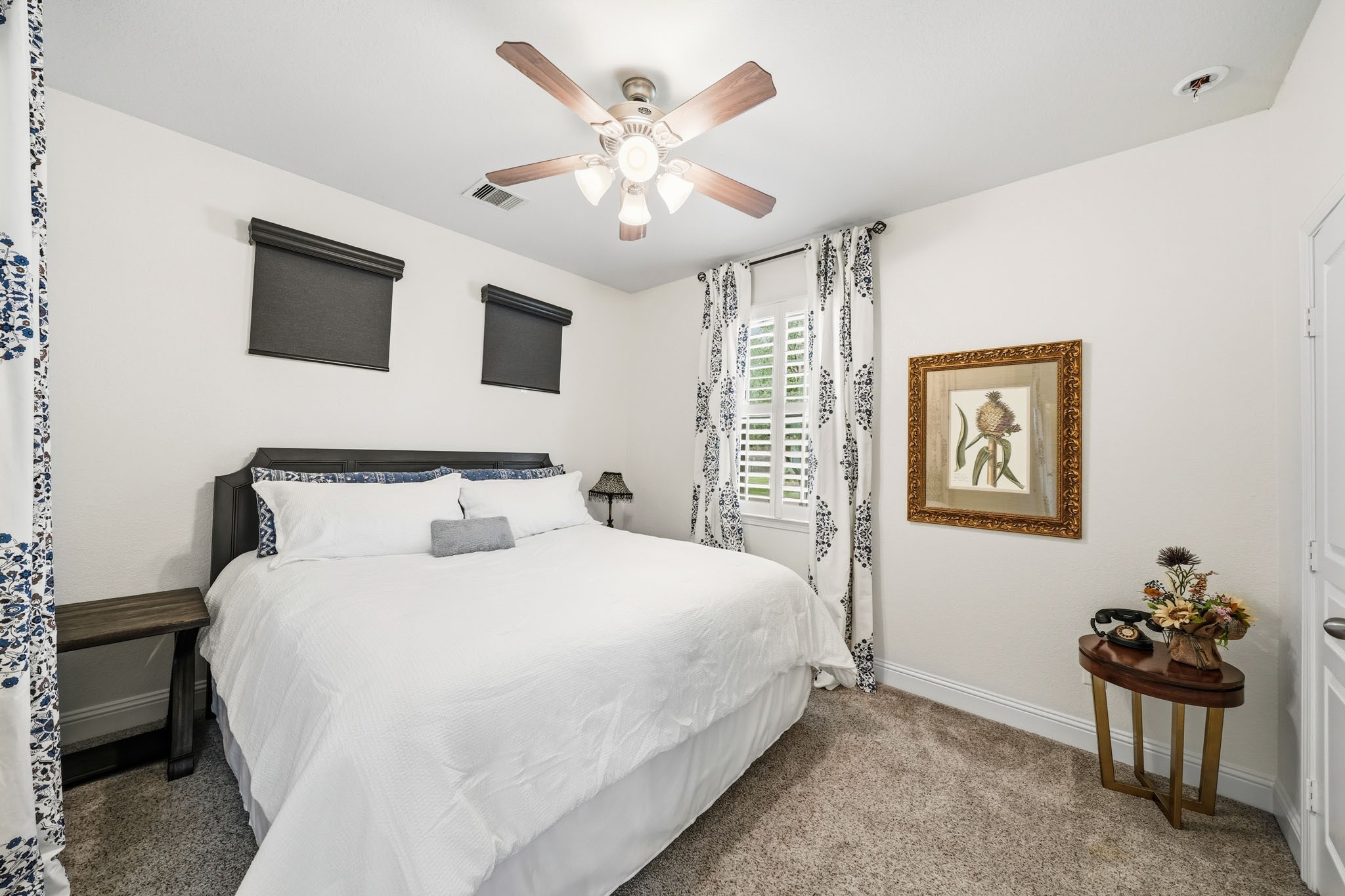 17610 Strackfield Lane Tomball, TX 77377 - Photo 31 of 50 The bedroom within the suite has windows with blinds, drapes and a ceiling fan with integrated light, creating a charming retreat for guests or multigenerational living.