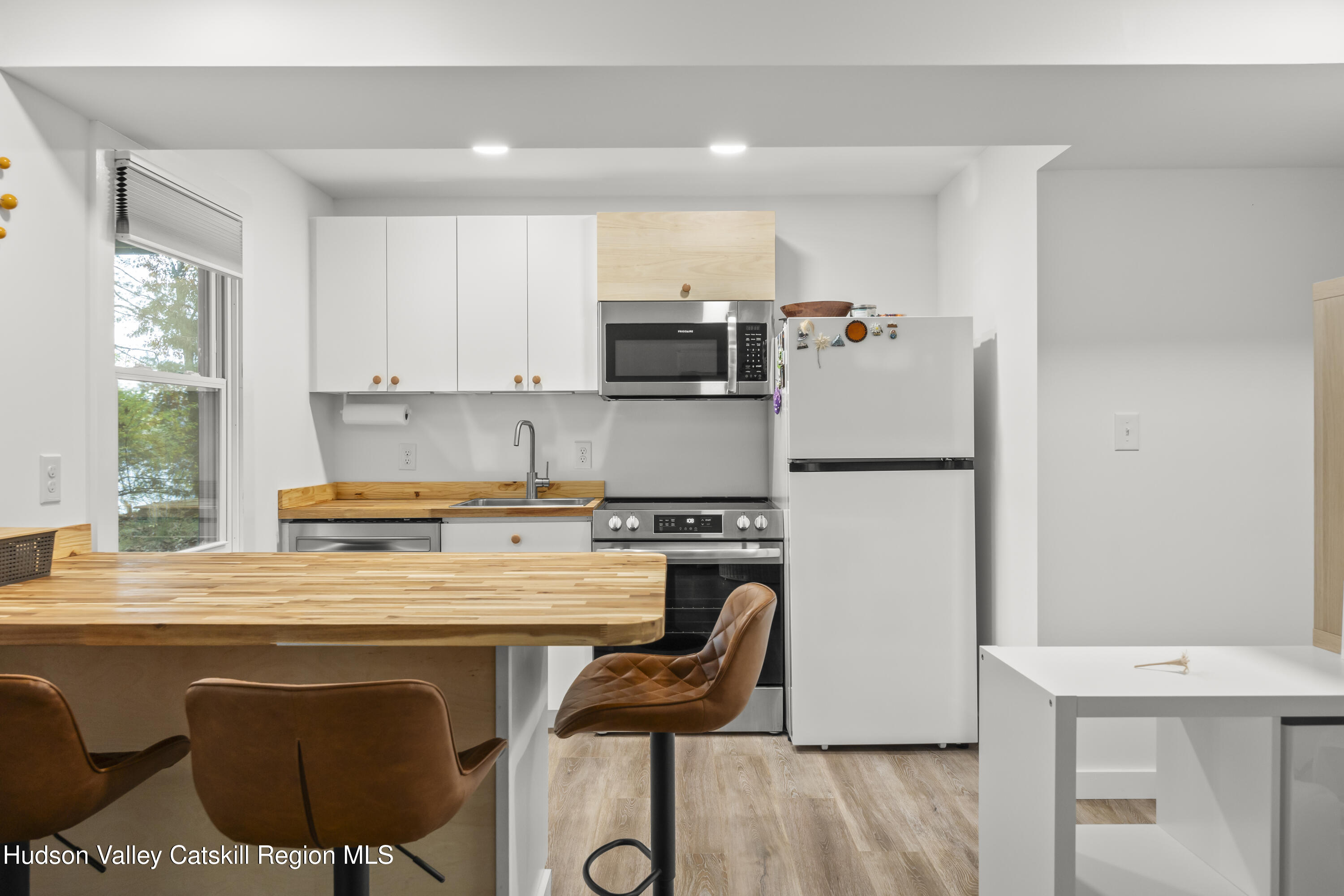 1256 Lakeview Road Copake, NY 12516 - Photo 28 of 37 a kitchen with stainless steel appliances granite countertop a stove a refrigerator a sink a stove and white cabinets with wooden floor