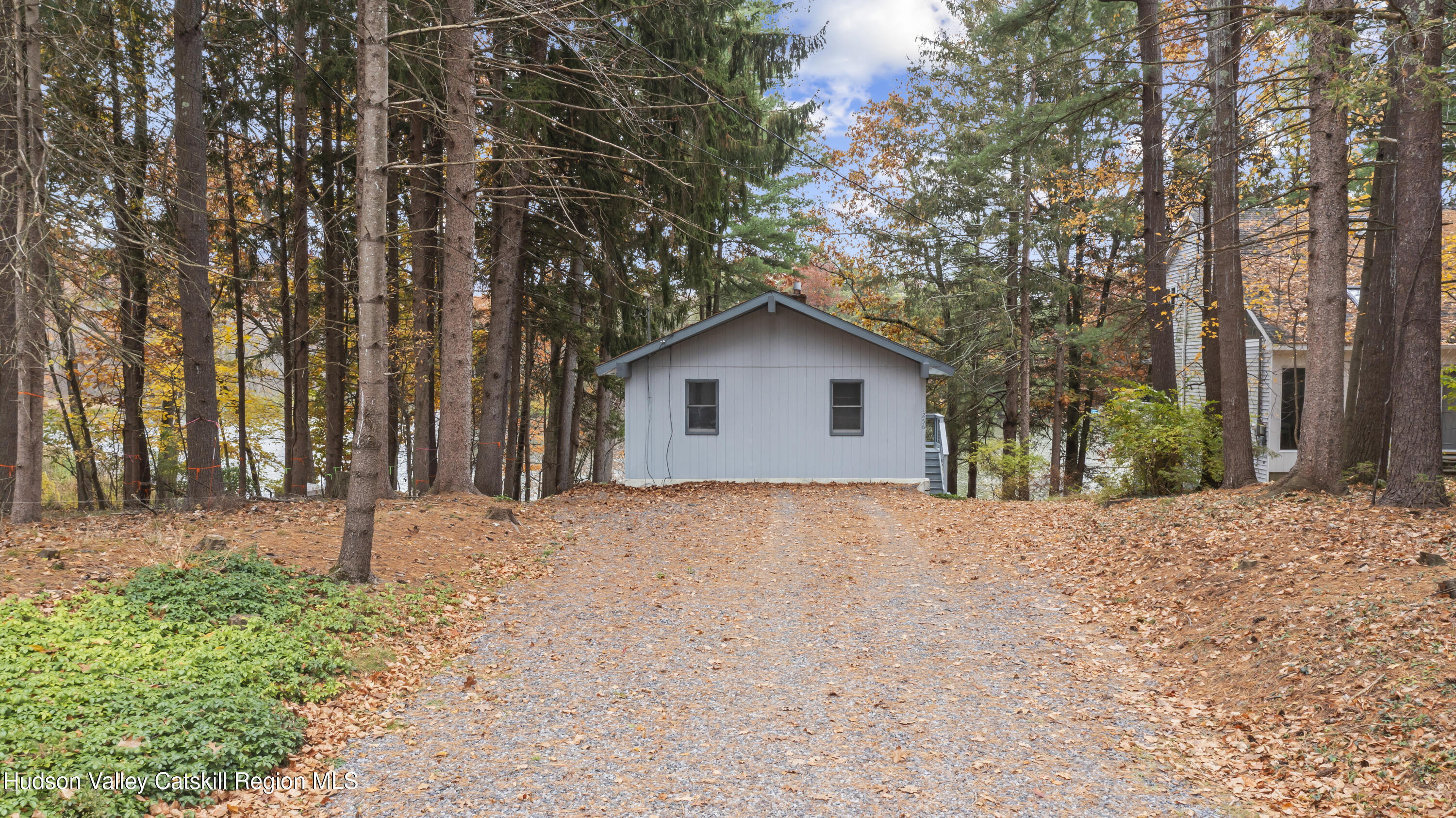 1256 Lakeview Road Copake, NY 12516 - Photo 9 of 37 a backyard of a house with large trees and covered with wooden fence
