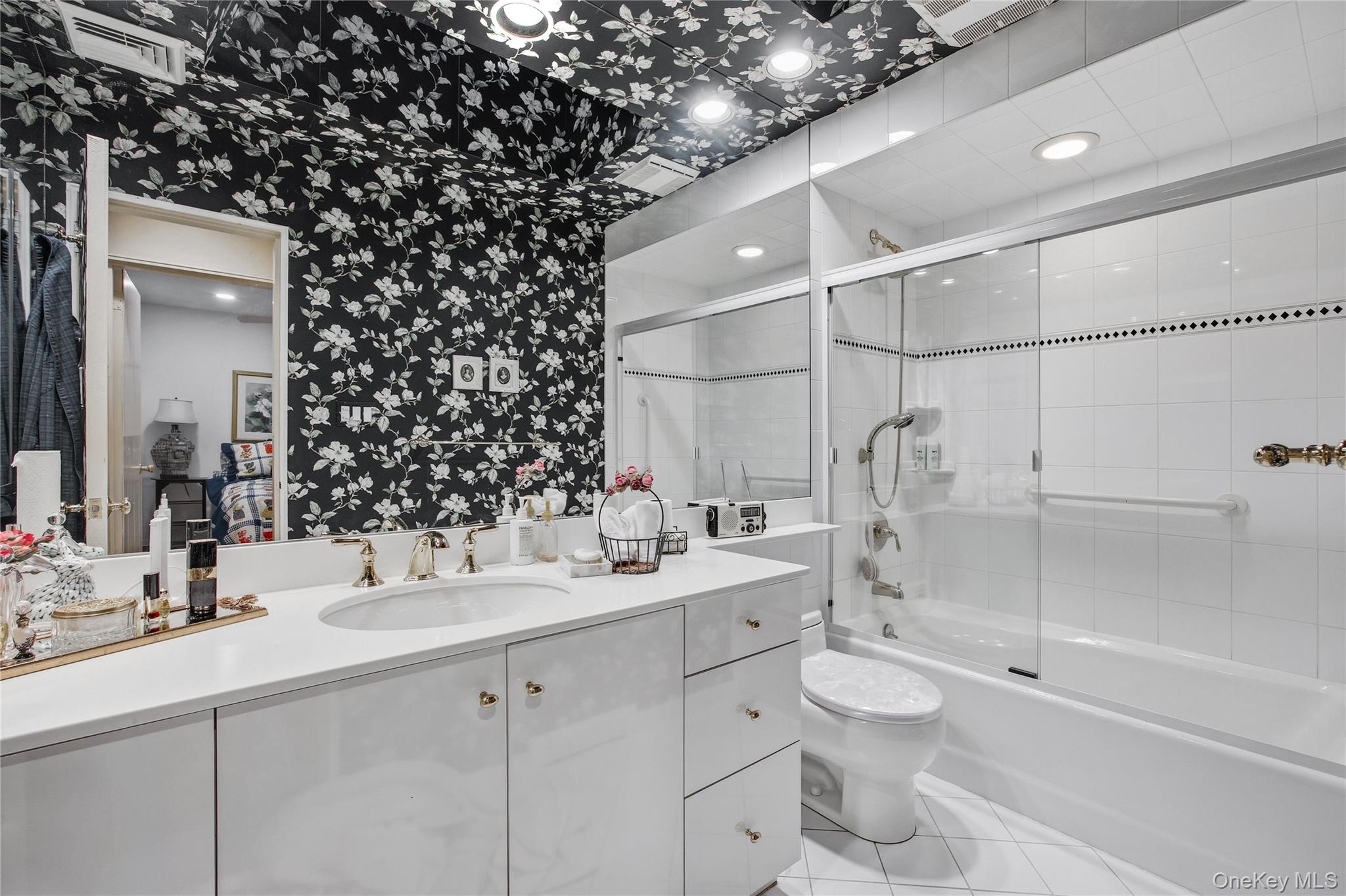 7 Judith Street Plainview, NY 11803 - Photo 29 of 45 Bathroom featuring wallpapered walls, vanity, light tile patterned floors, and shower / bath combination with glass door