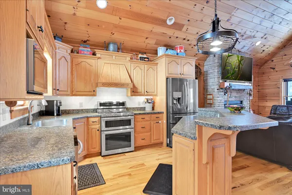 a kitchen with stainless steel appliances granite countertop a stove and cabinets