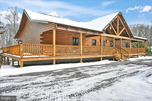 a front view of a house with a yard covered with snow
