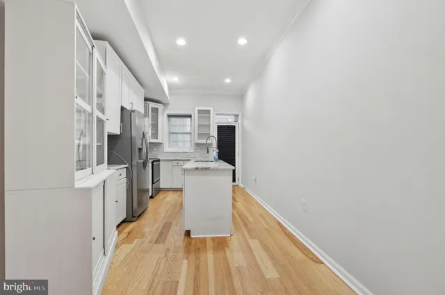a view of a kitchen with refrigerator and wooden floor