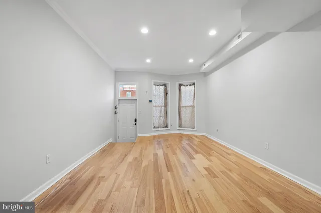 a view of empty room with wooden floor