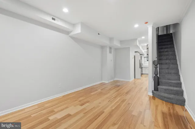 a view of empty room with wooden floor