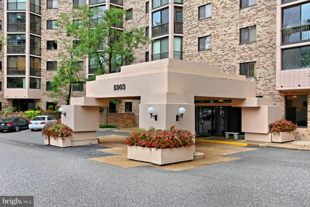 a front view of a building with parked cars