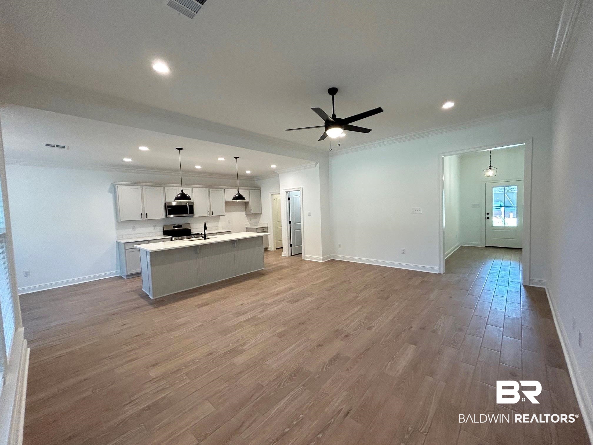 812 Sumter Loop Foley, AL 36535 - Photo 3 of 17 Kitchen featuring appliances with stainless steel finishes, decorative light fixtures, light hardwood / wood-style floors, and an island with sink