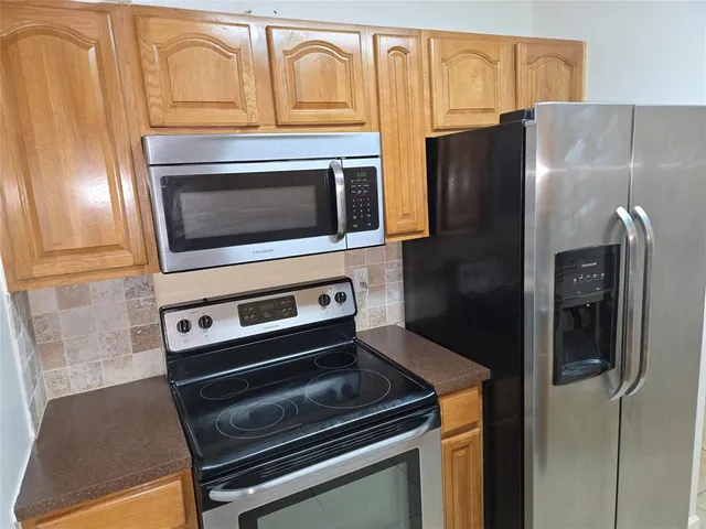 a kitchen with granite countertop cabinets and steel stainless steel appliances