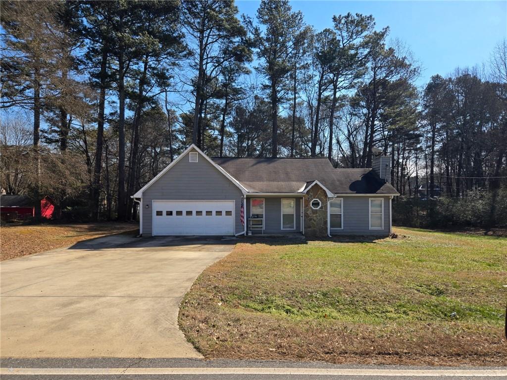 a front view of a house with yard and large trees