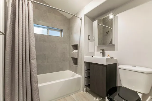 an empty room with wooden floor ceiling fan and windows