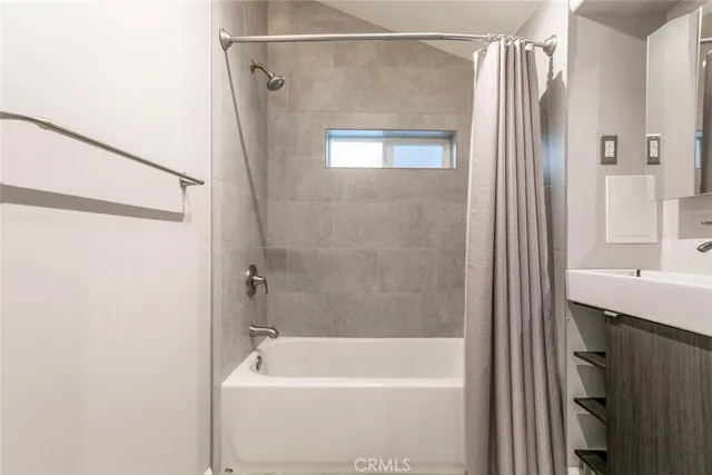 a spacious bathroom with a tub sink and mirror