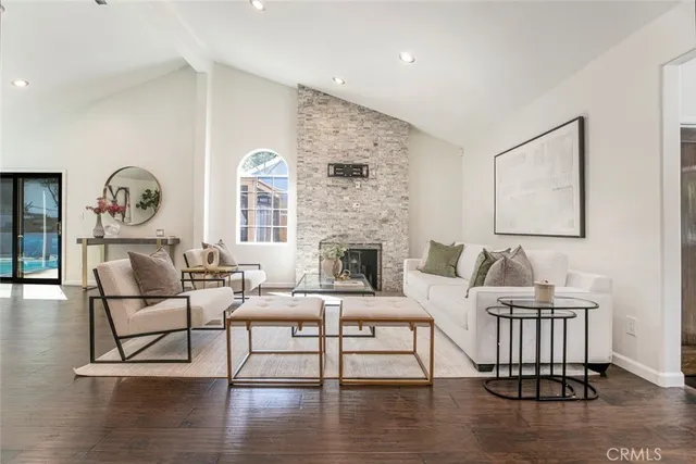 a living room with furniture a window and wooden floor
