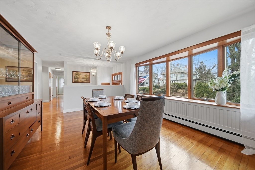 11 Lawrence Street Wakefield, MA 01880 - Photo 11 of 42 a dining room with wooden floor a chandelier a wooden table and chairs