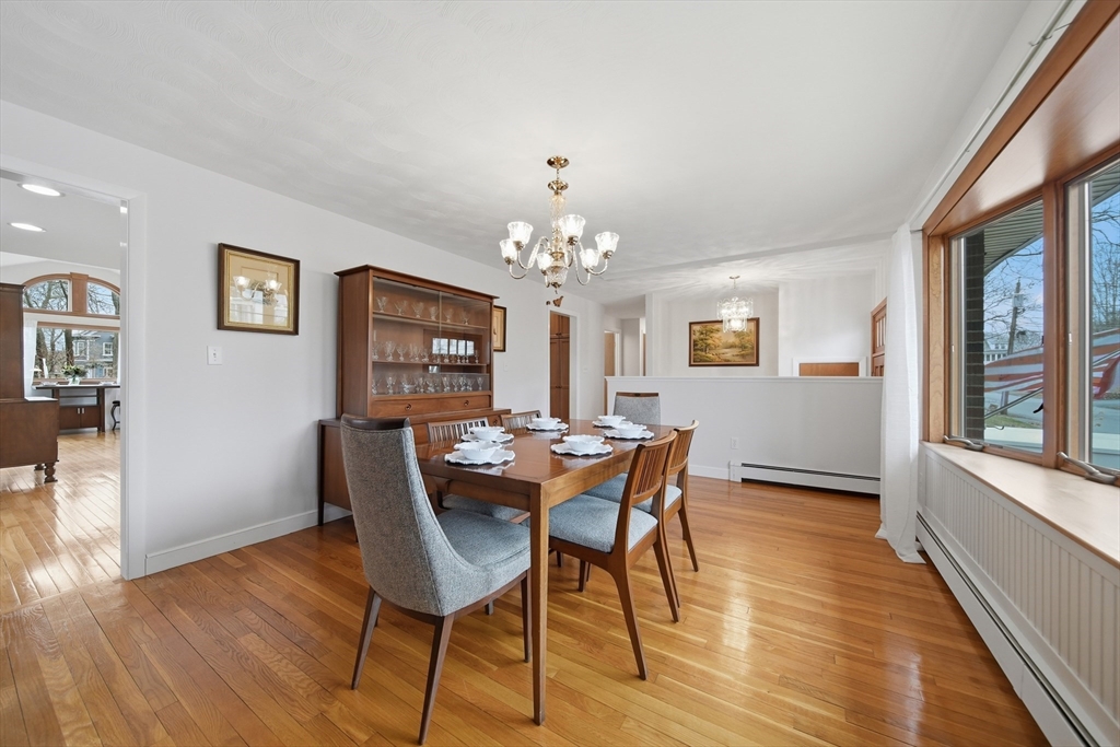11 Lawrence Street Wakefield, MA 01880 - Photo 12 of 42 a dining room with wooden floor a chandelier a wooden table and chairs