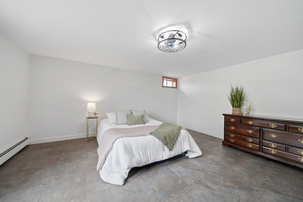 11 Lawrence Street Wakefield, MA 01880 - Photo 25 of 42 a bedroom with a bed and a potted plant on dresser