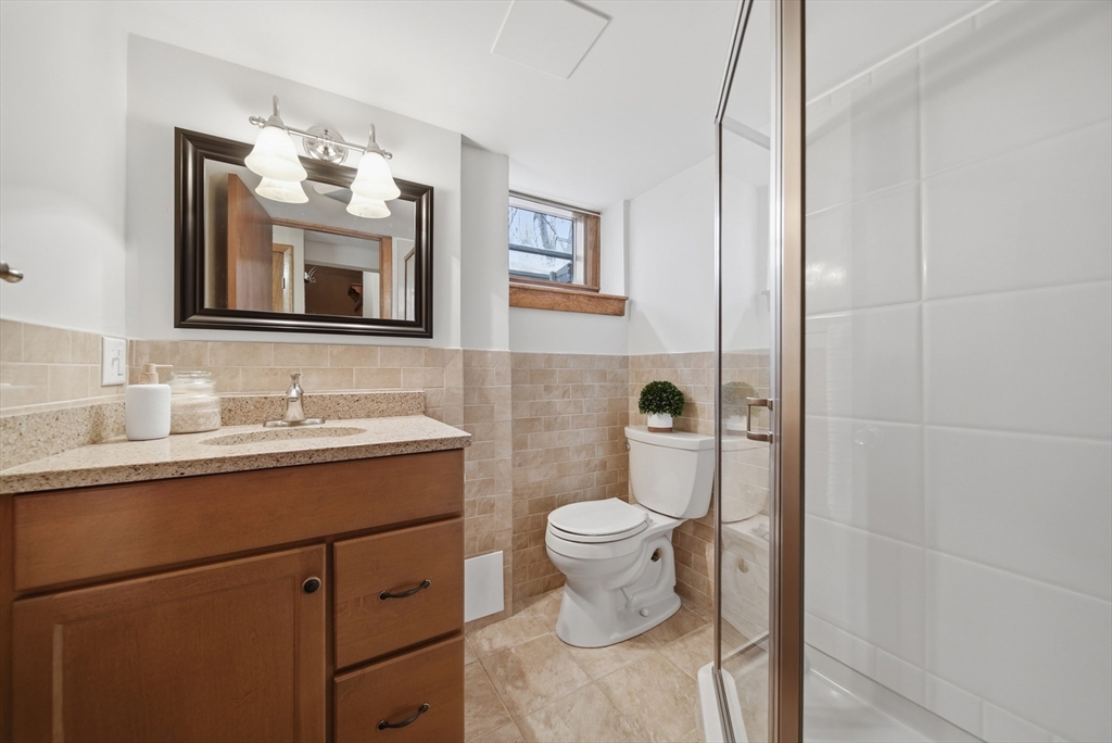 11 Lawrence Street Wakefield, MA 01880 - Photo 28 of 42 a bathroom with a granite countertop toilet sink and mirror