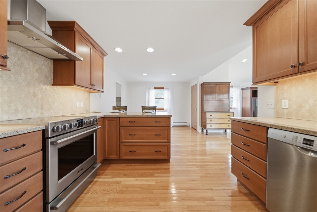 11 Lawrence Street Wakefield, MA 01880 - Photo 7 of 42 a kitchen with stainless steel appliances granite countertop a stove top oven a sink dishwasher and a refrigerator with wooden floor