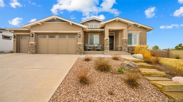 a front view of a house with a yard outdoor seating and garage