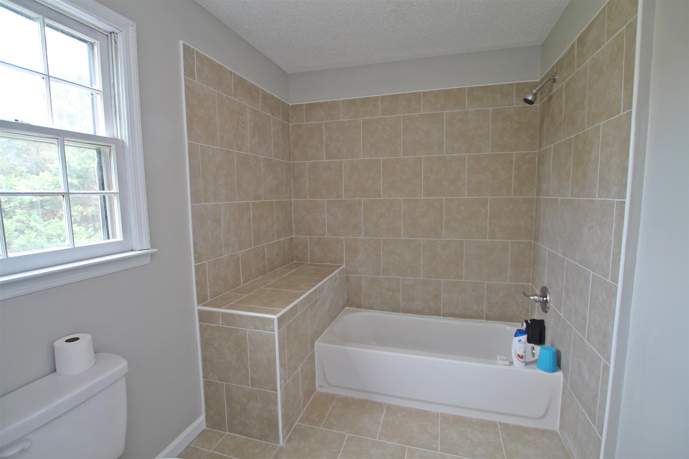 706 3rd Avenue West Springfield, TN 37172 - Photo 14 of 26 a bathroom with a bathtub a window a shower and vanity