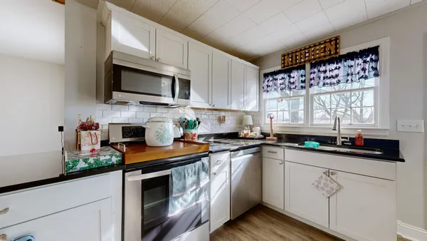 a kitchen with stainless steel appliances granite countertop a sink a stove top oven a counter space and cabinets