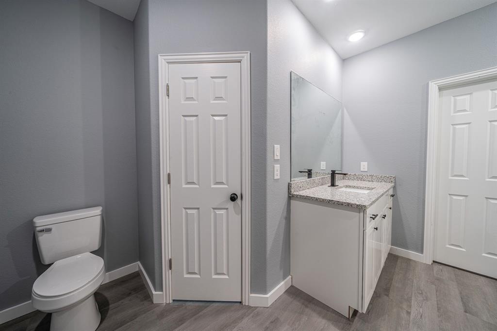 110 Red Oak Mabank, TX 75156 - Photo 13 of 30 a bathroom with a toilet sink and mirror