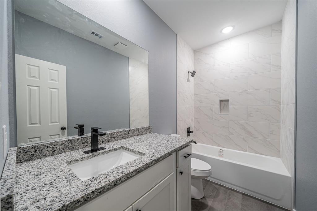 110 Red Oak Mabank, TX 75156 - Photo 18 of 30 a bathroom with a granite countertop sink toilet and shower