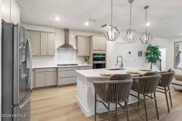 a kitchen with stainless steel appliances granite countertop a kitchen island a stove a table and chairs in it