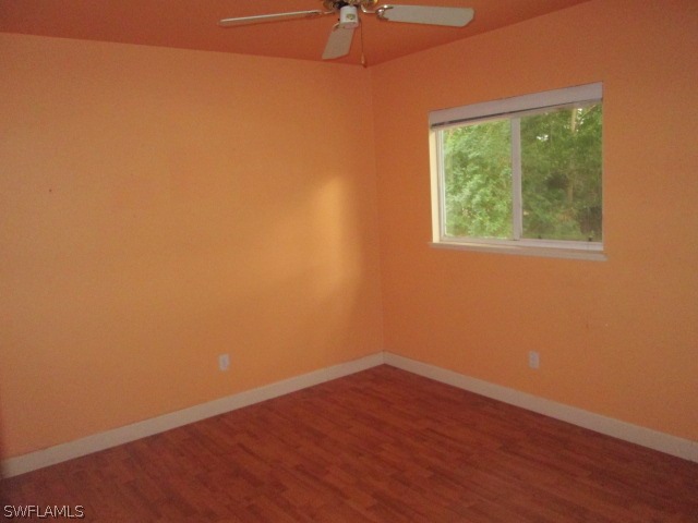 5615 Marina Road Bokeelia, FL 33922 - Photo 5 of 12 an empty room with wooden floor and a window