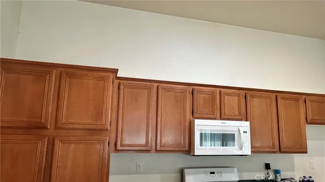 a kitchen with wooden cabinets and a microwave