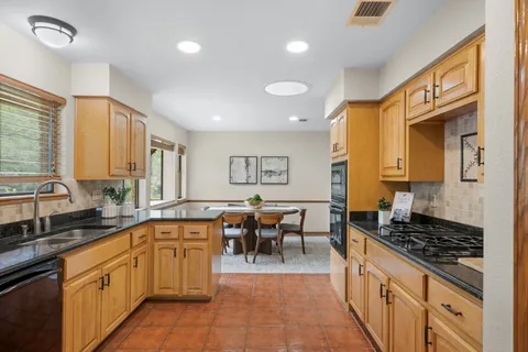 a large kitchen with lots of counter top space and stainless steel appliances