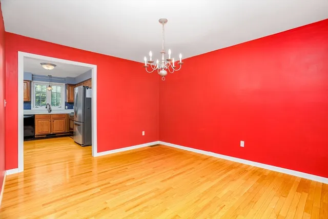 a view of a room with a chandelier fan and kitchen view