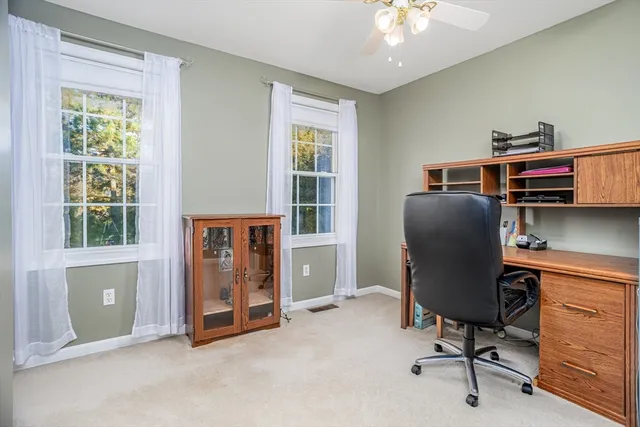 a view of a workspace with furniture and a window